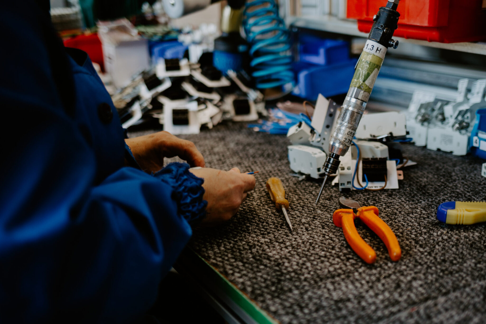 Electrician builder at work inspecting cabling connection of high voltage power electric line in industrial distribution fuseboard